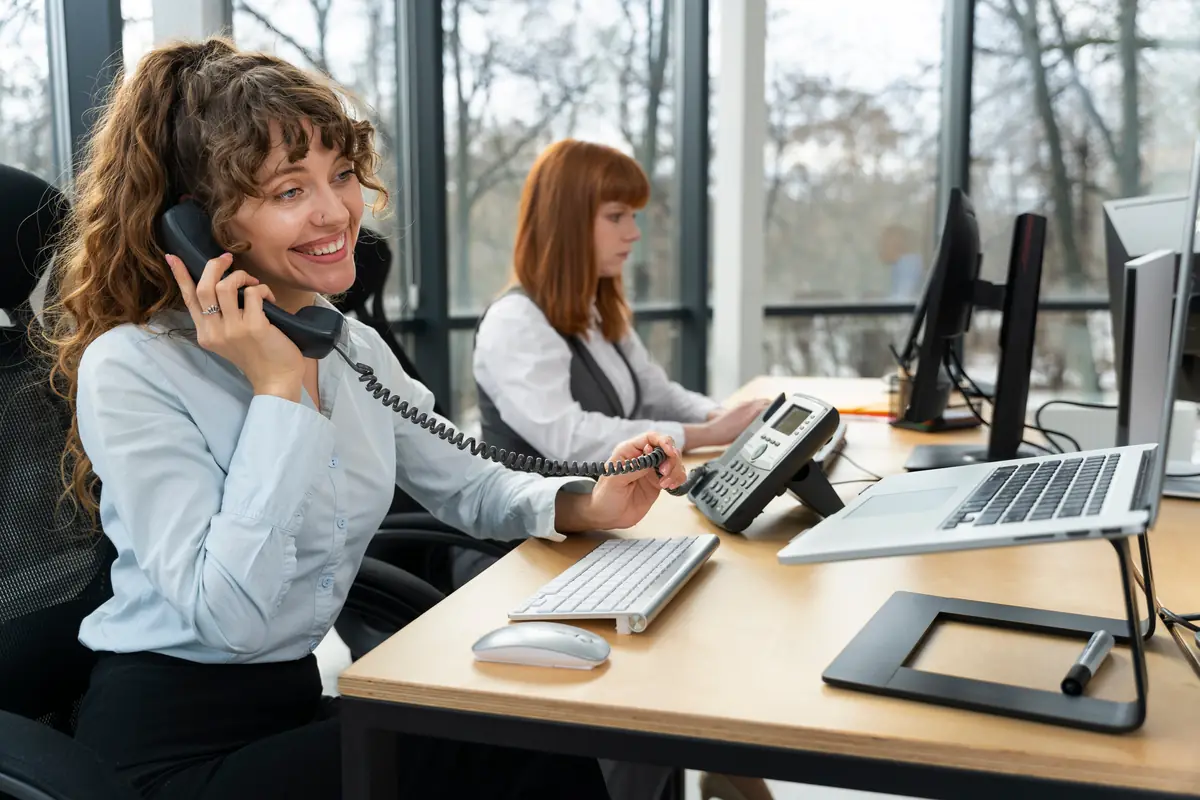 Salariée en appel sur un téléphone IP de bureau dans un open space